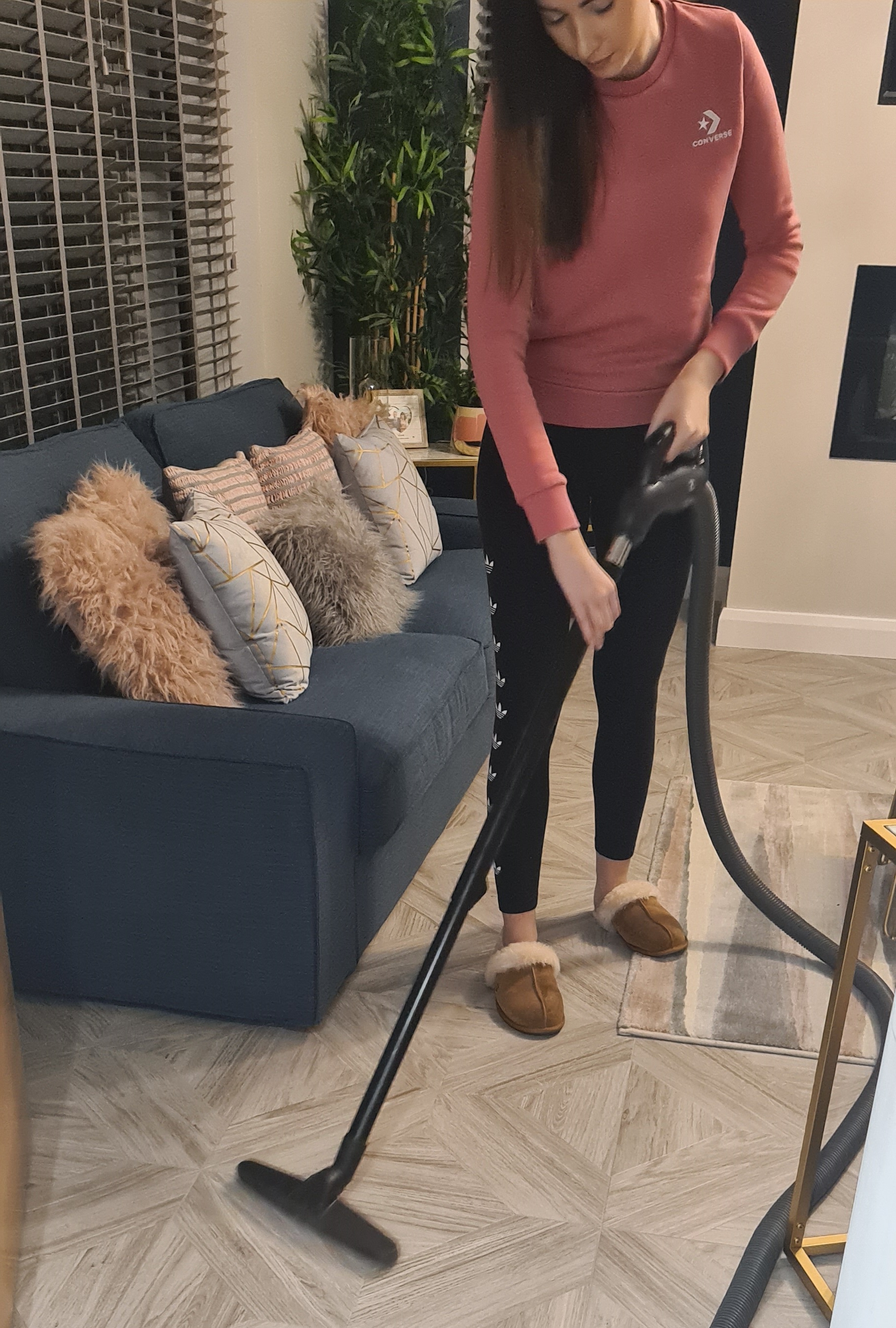 woman using Beam central vacuum on sitting room hard wood floor