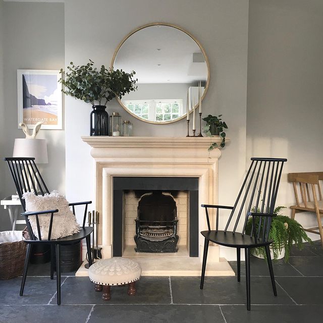 Black wooden chairs next to cream fireplace