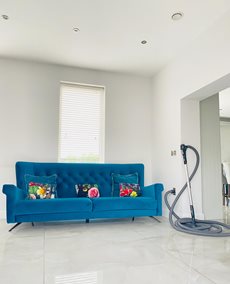 Beam-vacuum-hose-and-MVHR-valve-in-living-room-with-blue-sofa