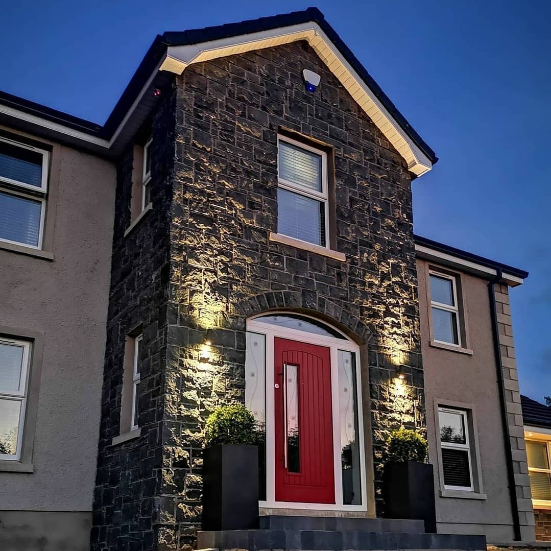 Grey block build house with red front door