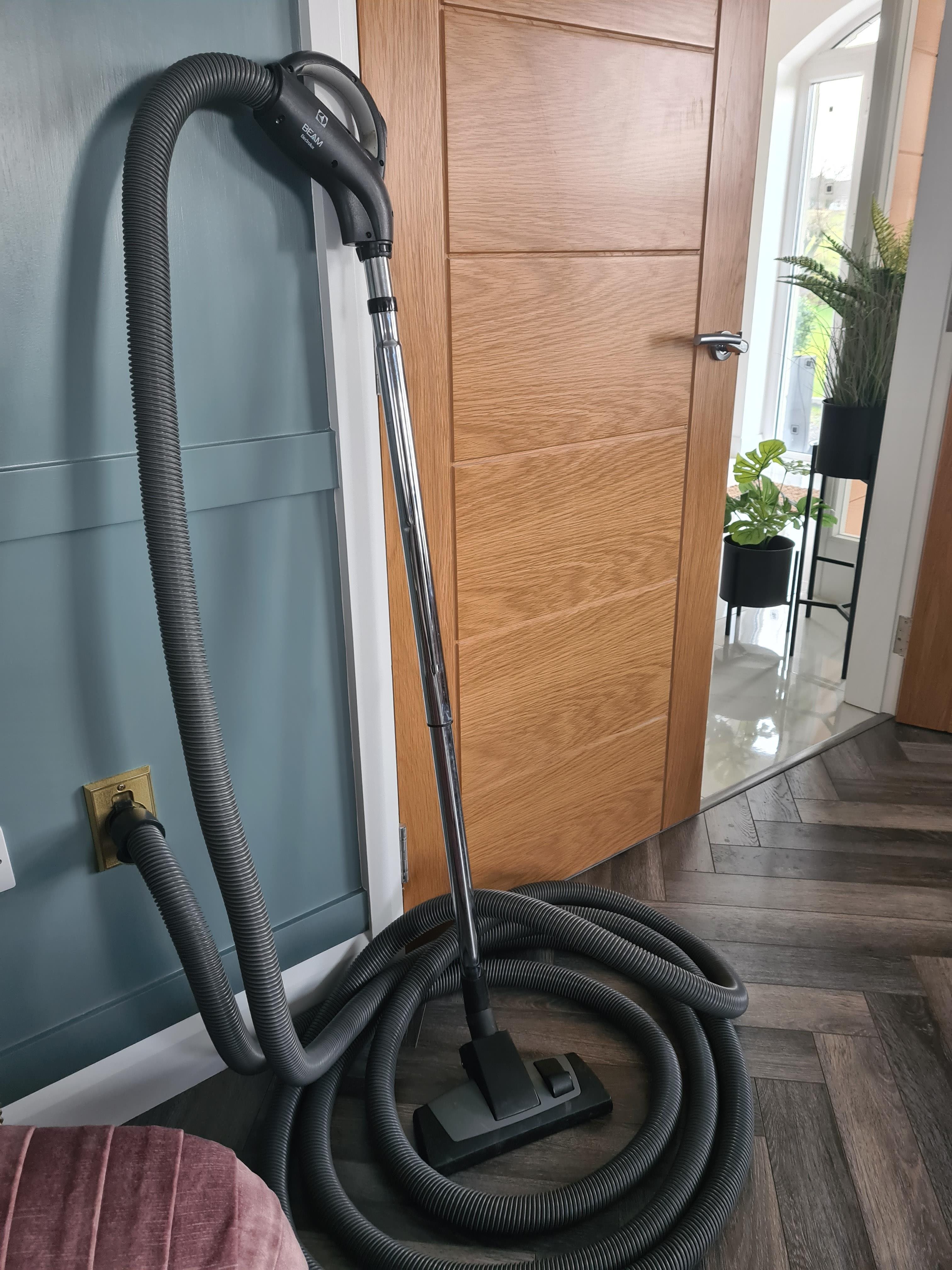 Beam Central vacuum hose against living room wall