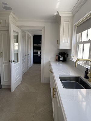 White and gold kitchen with dark wood utility room