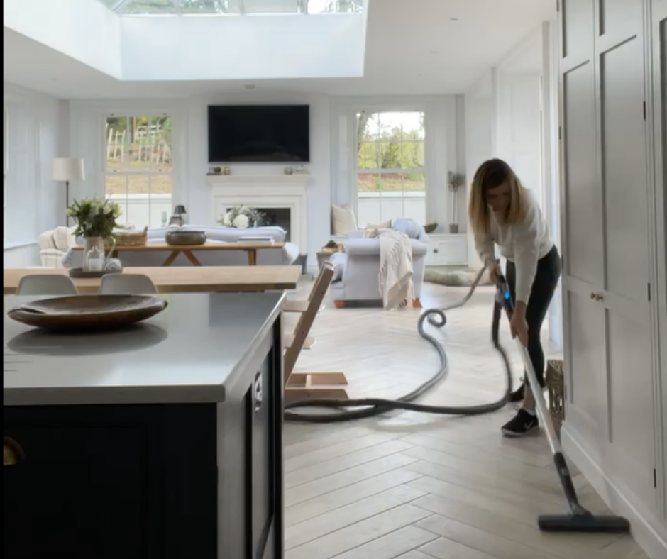 Woman vacuuming with Beam Central Vacuum in kitchen