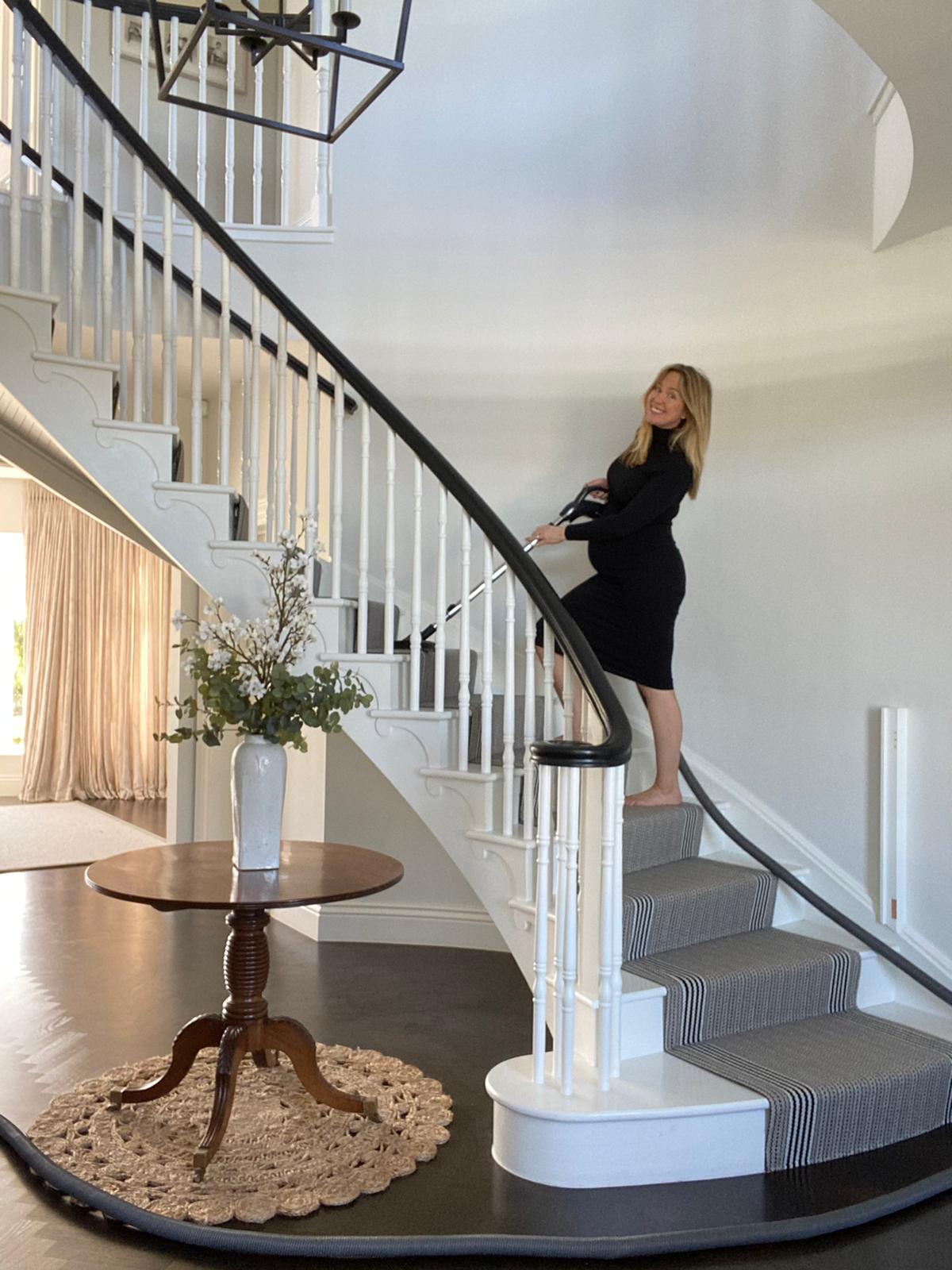 Woman vacuuming stairs with Beam Central Vacuum