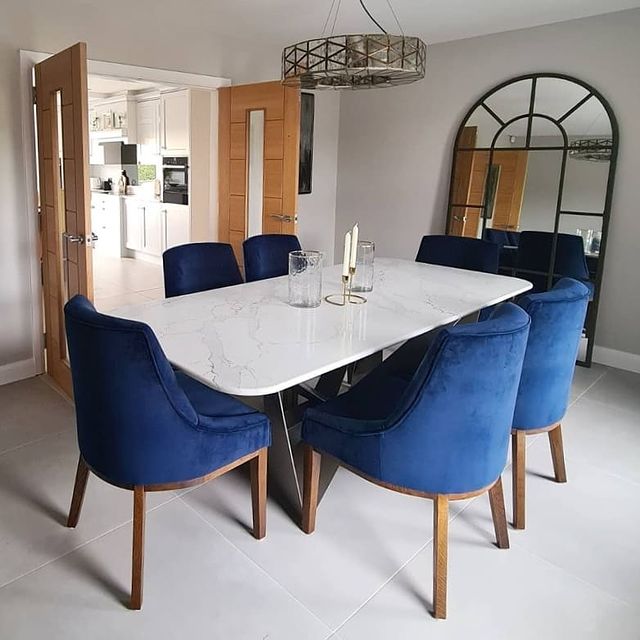 Dining room with blue chairs and large floor mirror